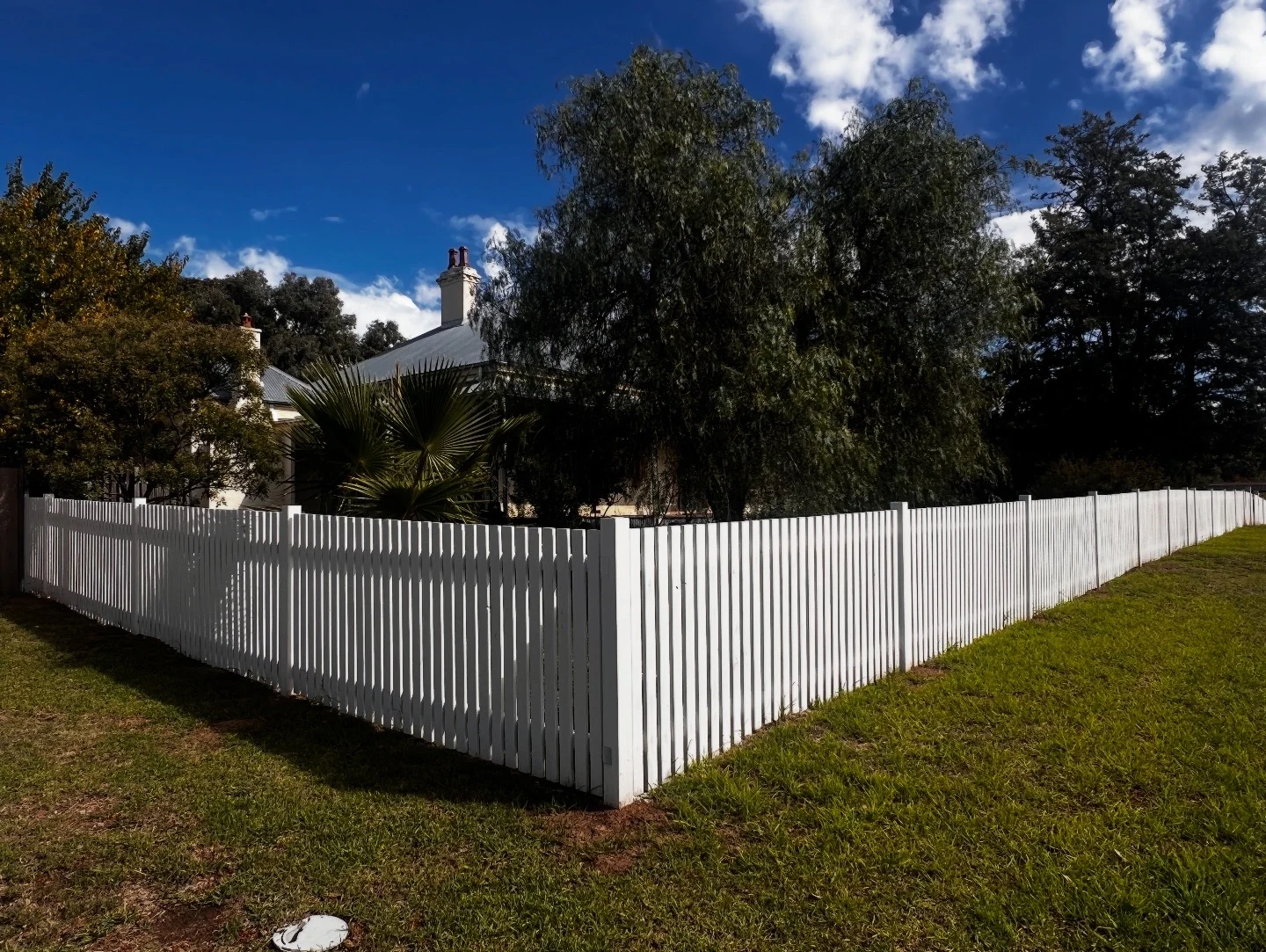 White picket fence along the front and side of a home