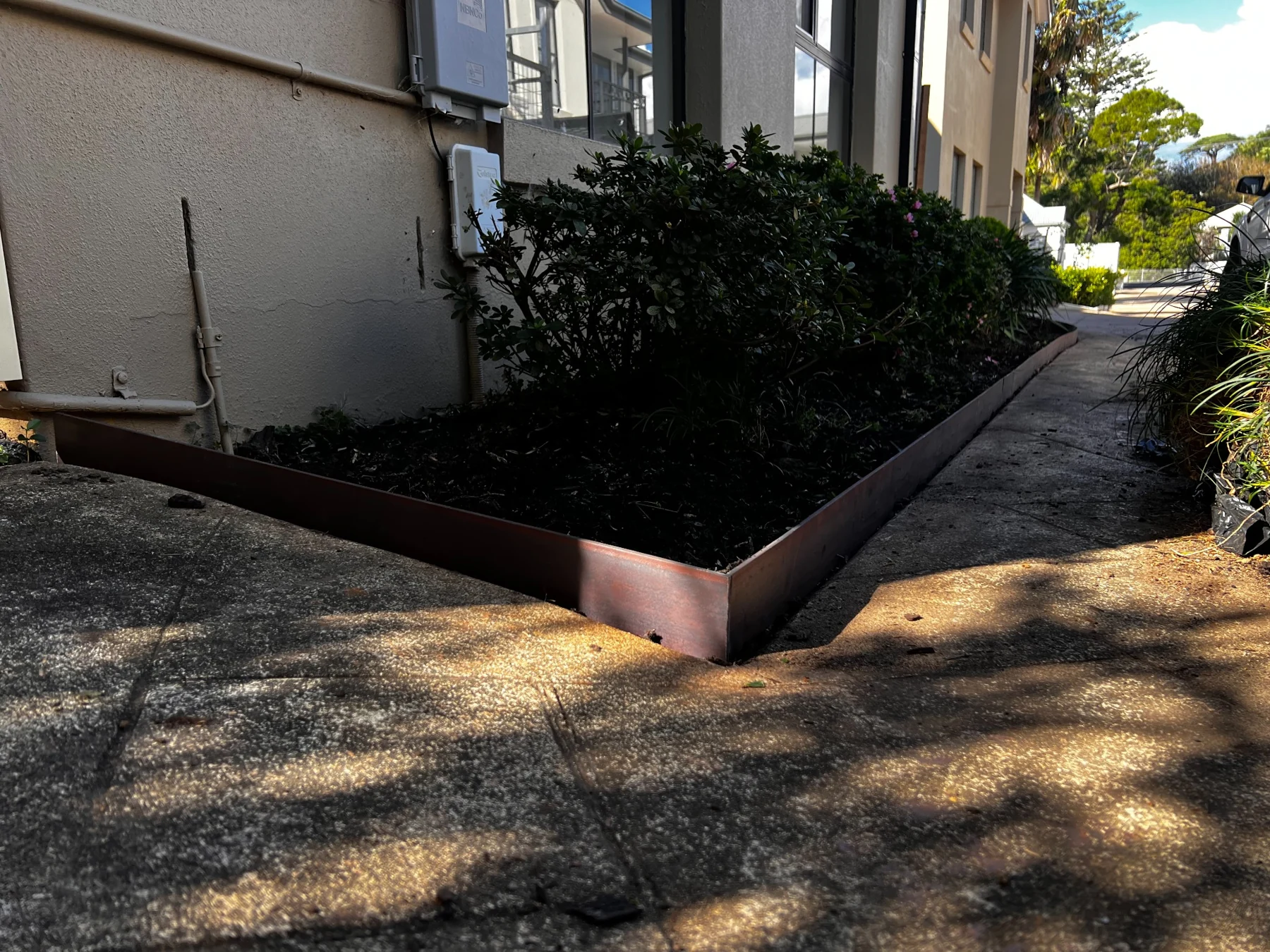 Weathered steel edging around a planted garden bed