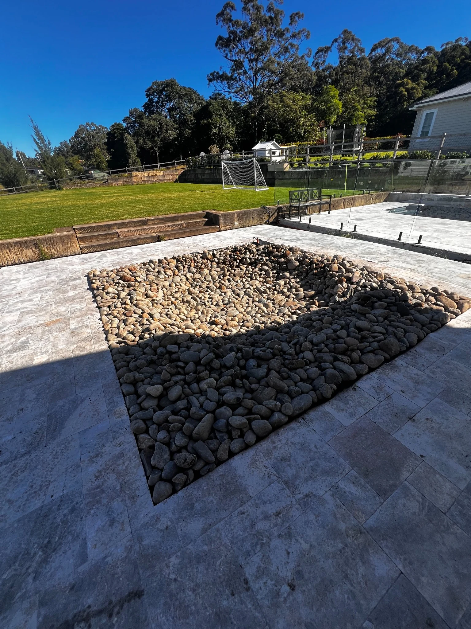 Stone terrace with sandstone steps and a lawn beyond