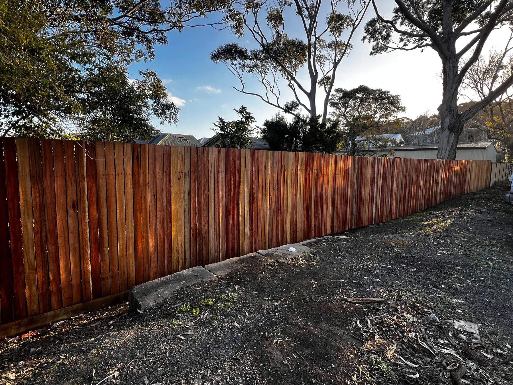 Timber paling fence following the slope of a garden