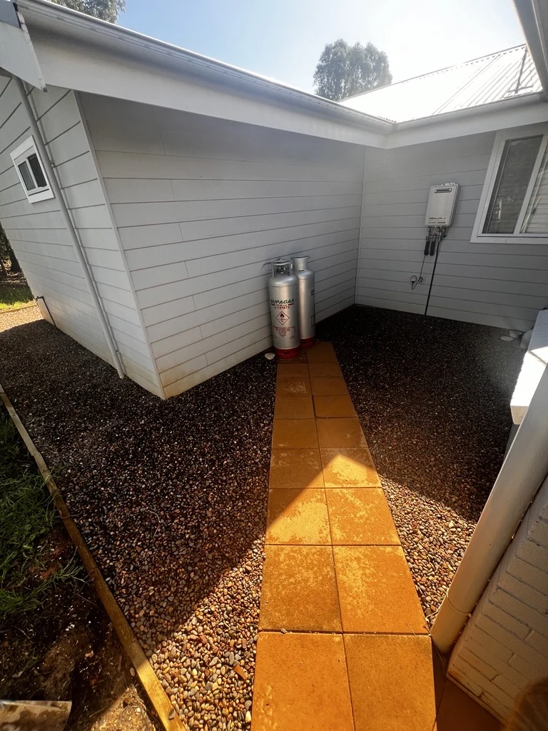 Warm-toned stone path between the house and garage